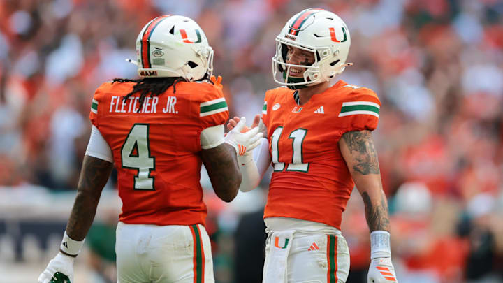 Sep 13, 2025; Miami Gardens, Florida, USA; Miami Hurricanes quarterback Carson Beck (11) celebrates with running back Mark Fletcher Jr. (4) after throwing a touchdown pass against the South Florida Bulls during the first quarter at Hard Rock Stadium. Mandatory Credit: Sam Navarro-Imagn Images