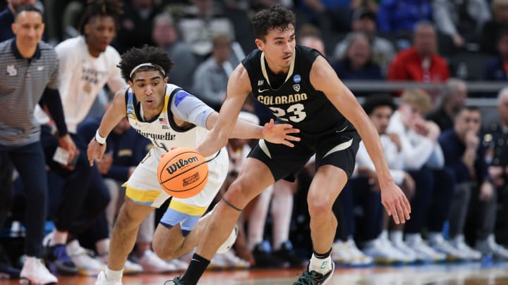 Marquette Golden Eagles guard Stevie Mitchell (4) knocks the ball away from Colorado Buffaloes forward Tristan da Silva (23) during the first half at Gainbridge FieldHouse. 