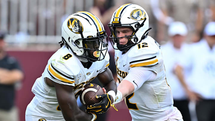Oct 5, 2024; College Station, Texas, USA; Missouri Tigers quarterback Brady Cook (12) hands off the ball to running back Nate Noel (8) in the fourth quarter against the Texas A&M Aggies at Kyle Field. Mandatory Credit: Maria Lysaker-Imagn Images. 