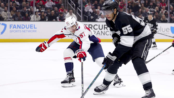 Mar 13, 2025; Los Angeles, California, USA; Washington Capitals defenseman Trevor van Riemsdyk (57) lunges for the puck against Los Angeles Kings right wing Quinton Byfield (55) during the second period at Crypto.com Arena. Mandatory Credit: Ryan Sun-Imagn Images