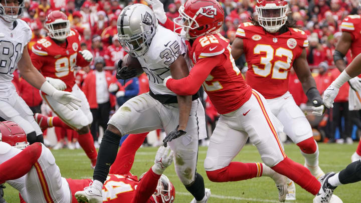 Dec 25, 2023; Kansas City, Missouri, USA; Las Vegas Raiders running back Zamir White (35) runs the ball as Kansas City Chiefs cornerback Trent McDuffie (22) makes the tackle during the game at GEHA Field at Arrowhead Stadium. Mandatory Credit: Denny Medley-USA TODAY Sports
