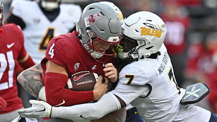 Oct 25, 2025; Pullman, Washington, USA; Washington State Cougars quarterback Zevi Eckhaus (4) is tackled by Toledo Rockets safety Emmanuel McNeil-Warren (7) in the second half at Gesa Field at Martin Stadium. 
