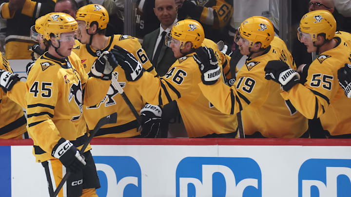 Oct 9, 2025; Pittsburgh, Pennsylvania, USA;  Pittsburgh Penguins defenseman Harrison Brunicke (45) celebrates his first NHL goal with the Penguins bench against the New York Islanders during the second period at PPG Paints Arena. Mandatory Credit: Charles LeClaire-Imagn Images