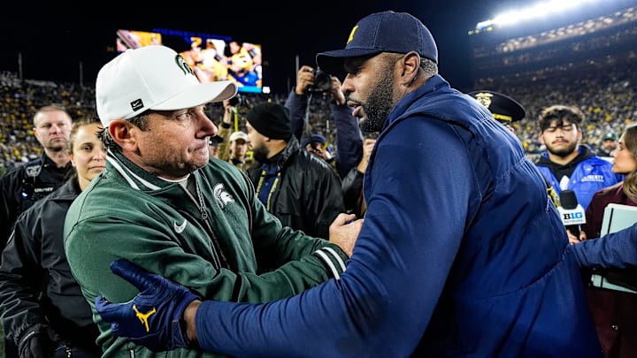 Michigan State Spartans head coach Jonathan Smith, left, shakes hands with Michigan head coach Sherrone Moore after 24-17 win for the Wolverines in Ann Arbor on Saturday, Oct. 26, 2024.