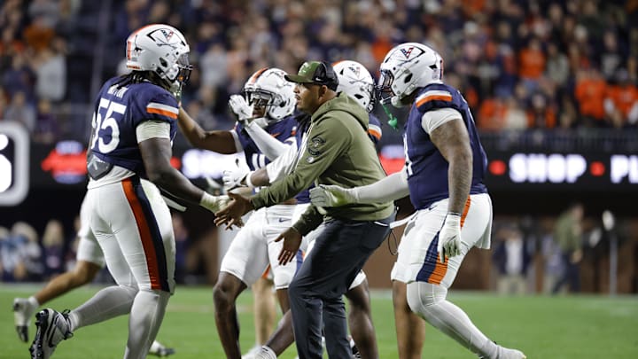 Nov 8, 2025; Charlottesville, Virginia, USA; Virginia Cavaliers head coach Tony Elliott (center) celebrates with players after a play against the Wake Forest Demon Deacons during the first half at Scott Stadium. Mandatory Credit: Amber Searls-Imagn Images