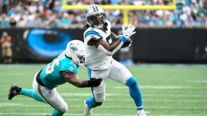 Oct 5, 2025; Charlotte, North Carolina, USA; Carolina Panthers running back Rico Dowdle (5) with the ball as Miami Dolphins linebacker Tyrel Dodson (25) defends in the second quarter at Bank of America Stadium. Mandatory Credit: Bob Donnan-Imagn Images