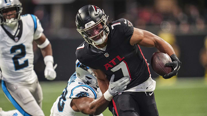 Jan 5, 2025; Atlanta, Georgia, USA; Atlanta Falcons running back Bijan Robinson (7) runs against Carolina Panthers linebacker D.J. Wonnum (98) during the first quarter at Mercedes-Benz Stadium. Mandatory Credit: Dale Zanine-Imagn Images
