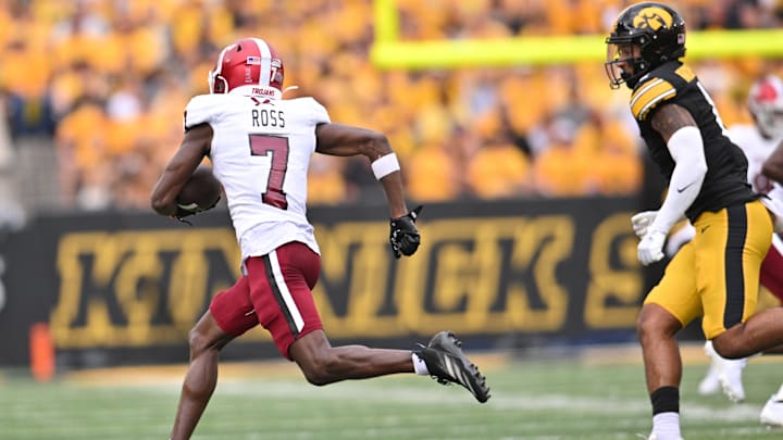 Troy Trojans wide receiver Devonte Ross (7) returns a punt 77 yards for a touchdown as Iowa Hawkeyes defensive back Xavier Nwankpa (1) pursues during the second quarter at Kinnick Stadium. 
