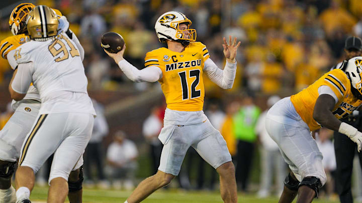 Sep 21, 2024; Columbia, Missouri, USA; Missouri Tigers quarterback Brady Cook (12) throws a touchdown pass against the Vanderbilt Commodores during overtime at Faurot Field at Memorial Stadium. Mandatory Credit: Jay Biggerstaff-Imagn Images