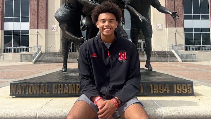 Trae Taylor in-front of a statue showcasing a national championship.