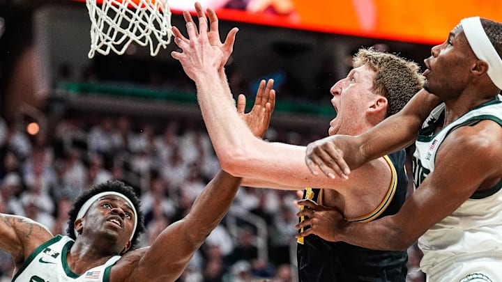 Michigan State forward Coen Carr (55), left, and Michigan center Danny Wolf (1), Michigan State guard Tre Holloman (5) battle for a rebound during the first half at Breslin Center in East Lansing on Sunday, March 9, 2025.