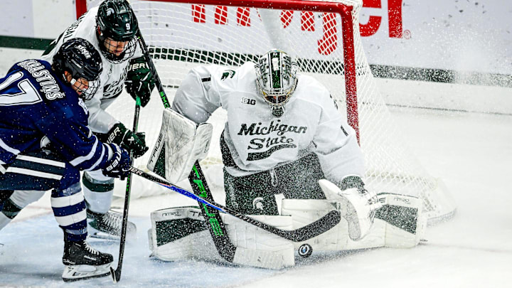 Michigan State's Trey Augustine blocks the goal from New Hampshire's Kristaps Skrastins, left, during the second period on Thursday, Oct. 9, 2025, at Munn Ice Arena in East Lansing.