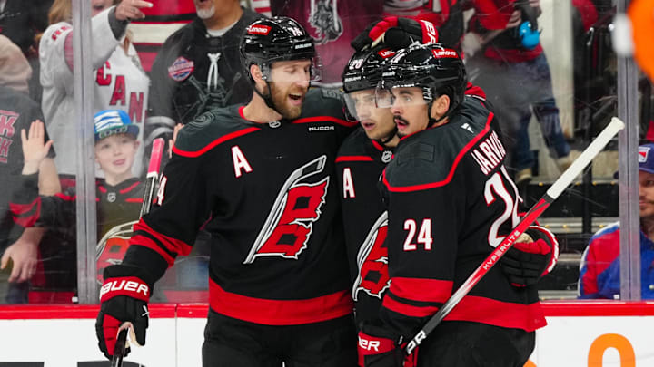 Apr 12, 2025; Raleigh, North Carolina, USA;  Carolina Hurricanes center Seth Jarvis (24) is congratulated by  center Sebastian Aho (20) and defenseman Jaccob Slavin (74) after his goal against the New York Rangers during the first period at Lenovo Center. Mandatory Credit: James Guillory-Imagn Images