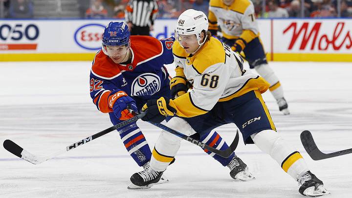 Nov 14, 2024; Edmonton, Alberta, CAN; Nashville Predators forward Zach L'Heureux (68) tries to move the puck past Edmonton Oilers forward Vasily Podkolzin (92) during the second period at Rogers Place. Mandatory Credit: Perry Nelson-Imagn Images