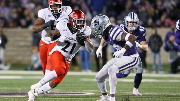 Nov 23, 2024; Manhattan, Kansas, USA; Cincinnati Bearcats running back Corey Kiner (21) tries to run by Kansas State Wildcats safety VJ Payne (19) during the second quarter at Bill Snyder Family Football Stadium. Mandatory Credit: Scott Sewell-Imagn Images
