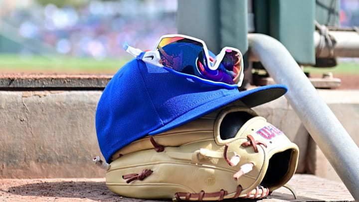 Feb 27, 2024; Mesa, Arizona, USA;  General view of a Chicago Cubs glove, hat and glasses in the first inning against the Cincinnati Reds during a spring training game at Sloan Park. Mandatory Credit: Matt Kartozian-Imagn Images