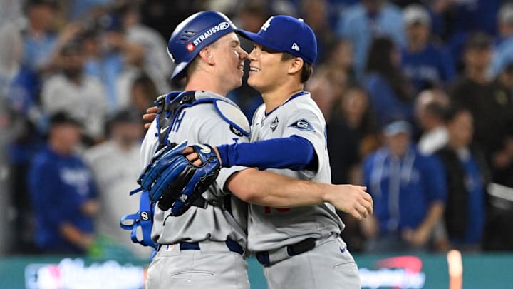 Oct 25, 2025; Toronto, Ontario, CAN; Los Angeles Dodgers pitcher Yoshinobu Yamamoto (18) and catcher Will Smith (16) celebrate after defeating the Toronto Blue Jays in game two of the 2025 MLB World Series at Rogers Centre. Mandatory Credit: Dan Hamilton-Imagn Images