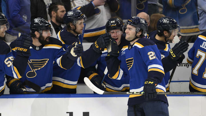 Apr 15, 2025; St. Louis, Missouri, USA; St. Louis Blues right wing Jimmy Snuggerud (21) is congratulated by teammates after scoring his first NHL goal against the Utah Hockey Club during the first period at Enterprise Center. Mandatory Credit: Jeff Le-Imagn Images
