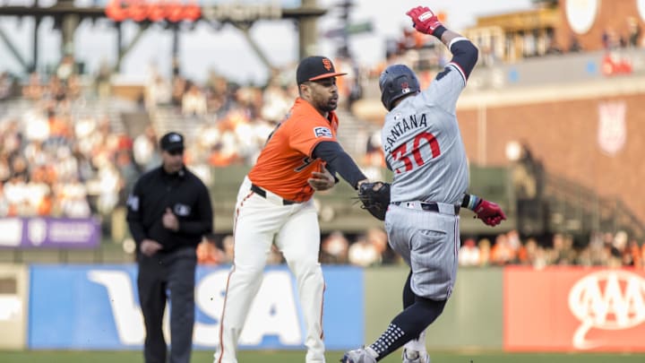 Jul 12, 2024; San Francisco, California, USA; San Francisco Giants first baseman LaMonte Wade Jr. (31) reaches for the ball to tag out Minnesota Twins first baseman Carlos Santana (30) during the first inning at Oracle Park.
