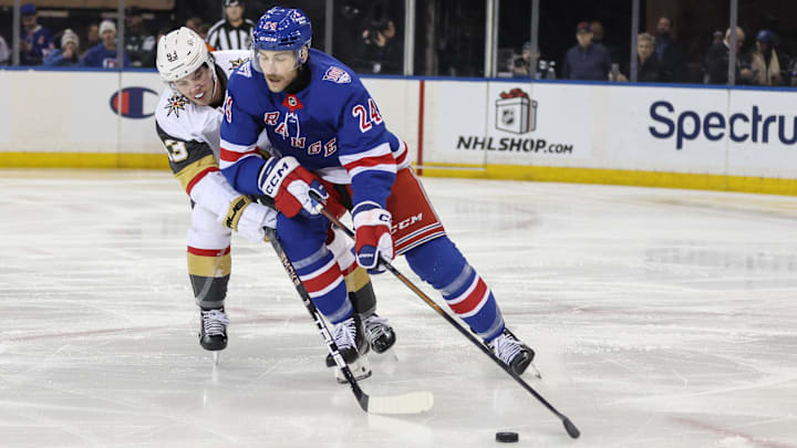 Dec 7, 2025; New York, New York, USA;  Vegas Golden Knights right wing Mitch Marner (93) and New York Rangers defenseman Carson Soucy (24) battle for control of the puck in the second period at Madison Square Garden. Mandatory Credit: Wendell Cruz-Imagn Images