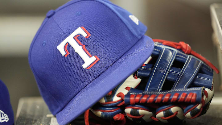 A hat and glove of a Texas Rangers player. A hat and glove of a Texas Rangers player.