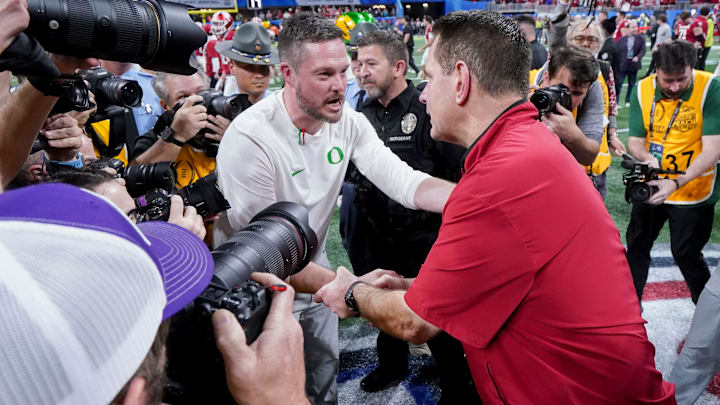 Indiana Hoosiers head coach Curt Cignetti shakes hands with Oregon Ducks head coach Dan Lanning on Friday, Jan. 9, 2026, after the Indiana Hoosiers defeated the Oregon Ducks in the Peach Bowl and semifinal game of the College Football Playoff at Mercedes-Benz Stadium in Atlanta.