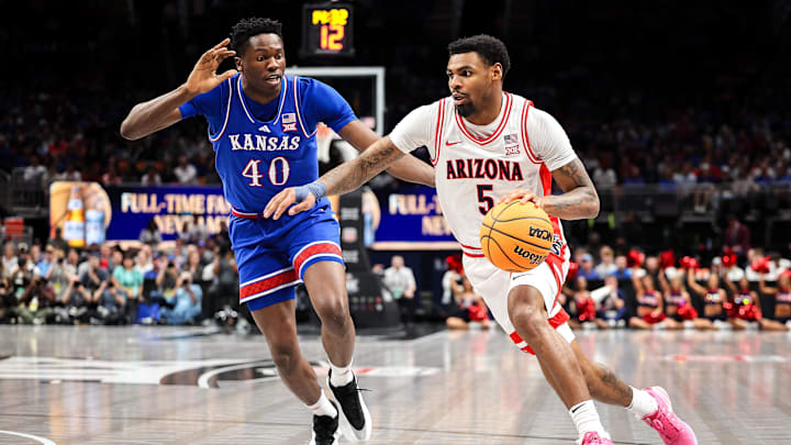 Mar 13, 2025; Kansas City, MO, USA; Arizona Wildcats guard KJ Lewis (5) drives to the basket around Kansas Jayhawks forward Flory Bidunga (40) during the first half at T-Mobile Center. Mandatory Credit: William Purnell-Imagn Images