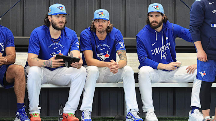 Toronto Blue Jays pitchers Cody Ponce (left), Kevin Gausman (center) and Dylan Cease (right) watch a bullpen session.