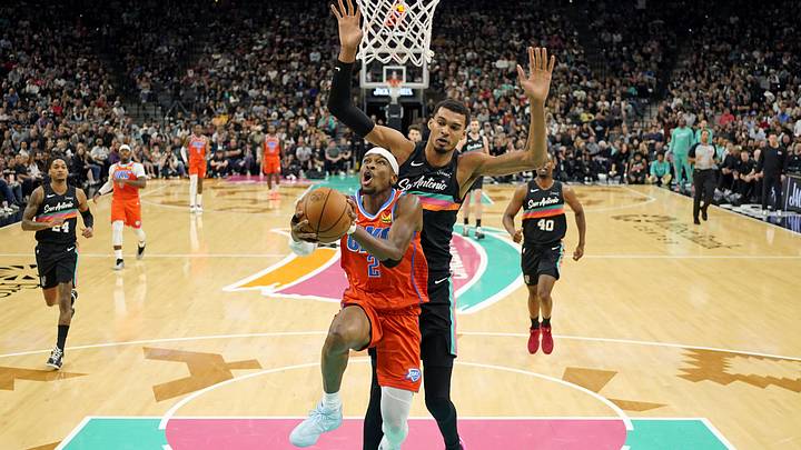 Dec 23, 2025; San Antonio, Texas, USA; Oklahoma City Thunder guard Shai Gilgeous-Alexander (2) drives to the basket past San Antonio Spurs forward Victor Wembanyama (1) during the first half at Frost Bank Center. Mandatory Credit: Scott Wachter-Imagn Images