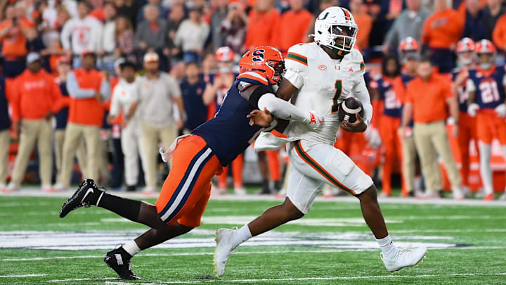 Nov 30, 2024; Syracuse, New York, USA; Syracuse Orange linebacker Marlowe Wax (left) tackles Miami Hurricanes quarterback Cam Ward (1) during the second half at the JMA Wireless Dome. Nov 30, 2024; Syracuse, New York, USA; Syracuse Orange linebacker Marlowe Wax (left) tackles Miami Hurricanes quarterback Cam Ward (1) during the second half at the JMA Wireless Dome.