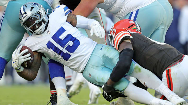 Dallas Cowboys running back Ezekiel Elliott (15) is wrapped up by Cleveland Browns linebacker Jeremiah Owusu-Koramoah (6).