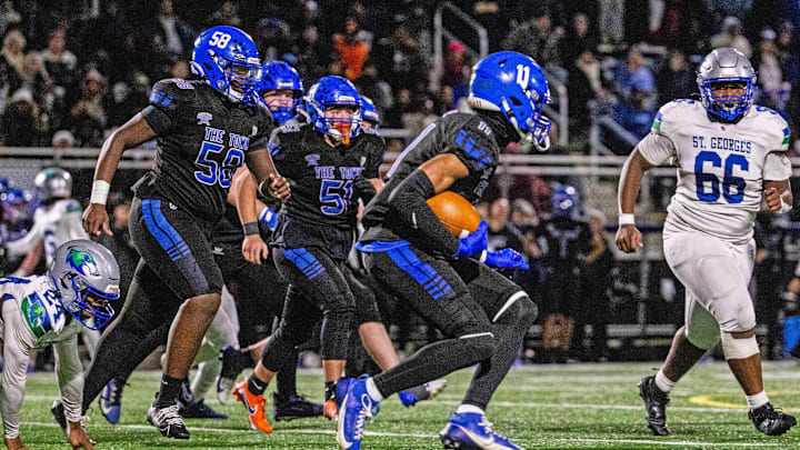 Middletown sophomore Daniel Davis (11) runs the ball as St. Georges junior Jahlil Settles (66) bears down during the DIAA football Class 3A semifinal game at Cavaliers Stadium in Middletown, Saturday, Nov. 23, 2024. Middletown won 24-7.