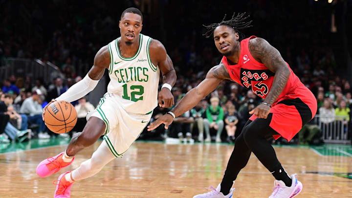Oct 13, 2024; Boston, Massachusetts, USA; Boston Celtics guard Lonnie Walker IV (12) controls the ball while Toronto Raptors guard Davion Mitchell (45) defends during the first half at TD Garden. Mandatory Credit: Bob DeChiara-Imagn Images