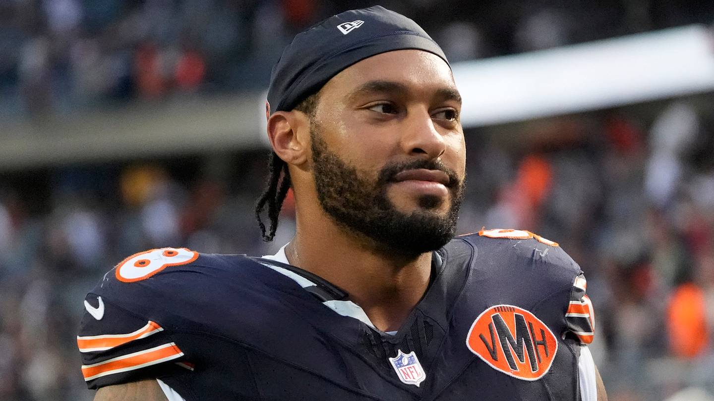 Due giocatori dei Chicago Bears si allontanano dal campo durante l'allenamento con il massaggiatore