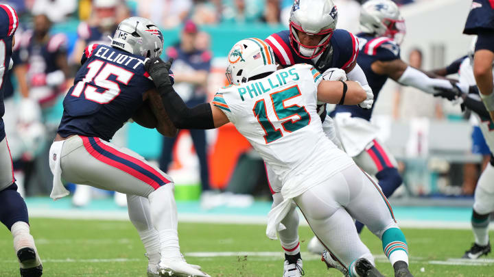 Oct 29, 2023; Miami Gardens, Florida, USA; Miami Dolphins linebacker Jaelan Phillips (15) reaches for New England Patriots running back Ezekiel Elliott (15) during the second half at Hard Rock Stadium. Oct 29, 2023; Miami Gardens, Florida, USA; Miami Dolphins linebacker Jaelan Phillips (15) reaches for New England Patriots running back Ezekiel Elliott (15) during the second half at Hard Rock Stadium.