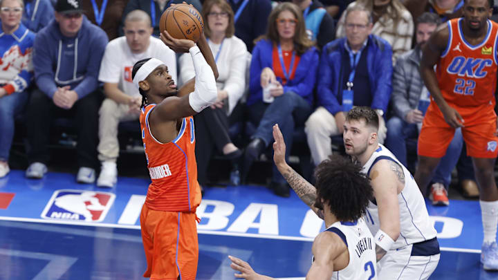 Dec 10, 2024; Oklahoma City, Oklahoma, USA; Oklahoma City Thunder guard Shai Gilgeous-Alexander (2) shoots over Dallas Mavericks guard Luka Doncic (77) and center Dereck Lively II (2) during the first quarter at Paycom Center. Mandatory Credit: Alonzo Adams-Imagn Images