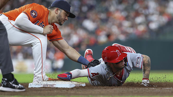 Sep 20, 2024; Houston, Texas, USA; Los Angeles Angels shortstop Zach Neto (9) slides back into first base on a pickoff attempt as Houston Astros first baseman Yainer Diaz (21) attempts to apply a tag during the fifth inning at Minute Maid Park. Mandatory Credit: Troy Taormina-Imagn Images