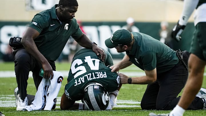 Sep 13, 2025; East Lansing, Michigan, USA; Michigan State linebacker Brady Pretzlaff (45) receives care from the athletic trainers during a game against Youngstown State at Spartan Stadium. Mandatory Credit: Brendan Mullin-Imagn Images