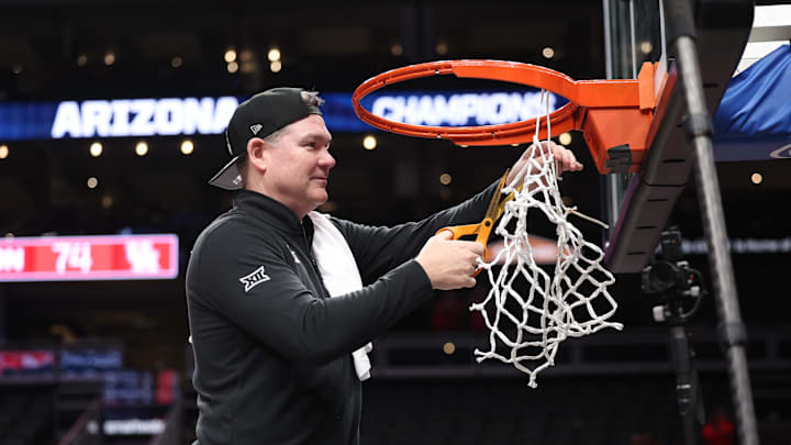 Mar 14, 2026; Kansas City, MO, USA; Arizona Wildcats head coach Tommy Lloyd cuts the net after a win over the Houston Cougars during the men's Big 12 Conference Tournament Championship at T-Mobile Center. Mandatory Credit: William Purnell-Imagn Images