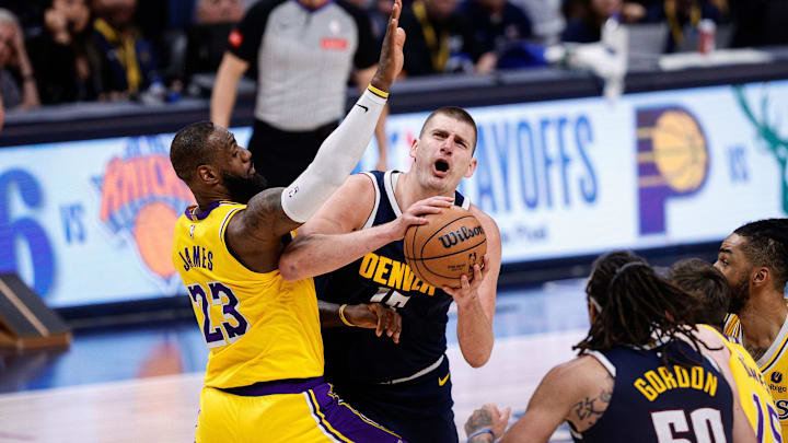 Denver Nuggets center Nikola Jokic (15) drives to the net against Los Angeles Lakers forward LeBron James (23) in the fourth quarter during game five of the first round for the 2024 NBA playoffs at Ball Arena. Mandatory Credit: Isaiah J. Downing-Imagn Images