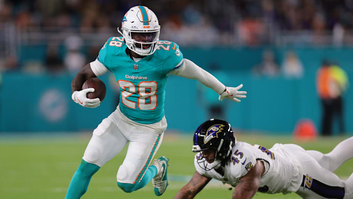 Oct 30, 2025; Miami Gardens, Florida, USA; Miami Dolphins running back De'Von Achane (28) runs for a gain past Baltimore Ravens linebacker Mike Green (45) during the first quarter at Hard Rock Stadium. 