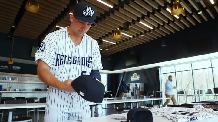 Hudson Valley Renegades outfielder Brendan Jones signs a hat during media day on April 1, 2025.