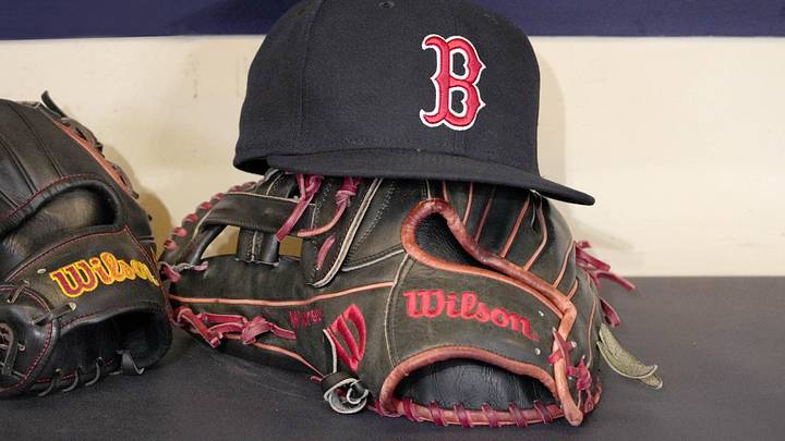 May 27, 2025; Milwaukee, Wisconsin, USA; A Boston Red Sox hat and glove sit in the dug out before a game against the Milwaukee Brewers at American Family Field. Mandatory Credit: Michael McLoone-Imagn Images