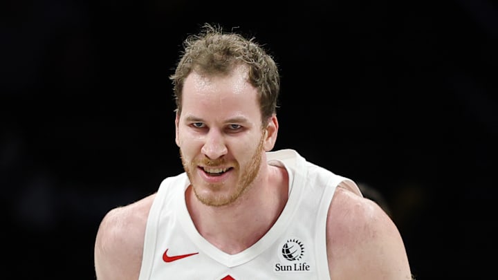 Scotty Barnes cheerfully slaps Jakob Poeltl while running back on defense.