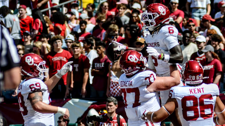 Oklahoma running back Tory Blaylock celebrates a touchdown with offensive lineman Heath Ozaeta.