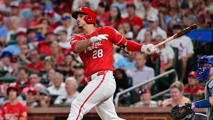 Aug 17, 2024; St. Louis, Missouri, USA;  St. Louis Cardinals third base Nolan Arenado (28) hits a solo home run against the Los Angeles Dodgers in the eighth inning at Busch Stadium.  At right is Los Angeles Dodgers catcher Will Smith. Mandatory Credit: Tim Vizer-Imagn Images