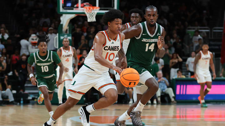 Nov 3, 2025; Coral Gables, Florida, USA; Miami Hurricanes guard Tru Washington (10) drives to the basket against Jacksonville Dolphins forward Allen Udemadu (14) during the first half at Watsco Center. Mandatory Credit: Sam Navarro-Imagn Images