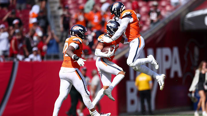 Sep 22, 2024; Tampa, Florida, USA; Denver Broncos safety Brandon Jones (22) and linebacker Jonathon Cooper (0) celebrate after a fumble recovery against the Tampa Bay Buccaneers in the fourth quarter at Raymond James Stadium. 