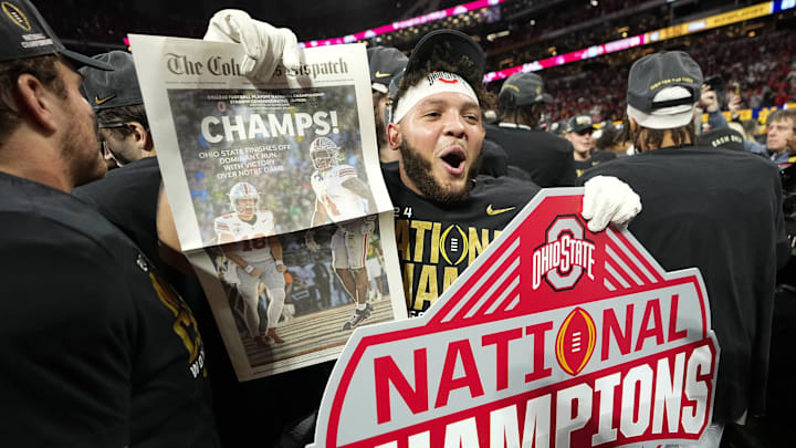 Ohio State Buckeyes wide receiver Brandon Inniss (11) celebrates with a commemorative copy of The Columbus Dispatch following the 34-23 win over the Notre Dame Fighting Irish to win the College Football Playoff National Championship at Mercedes-Benz Stadium in Atlanta on Jan. 22, 2025.