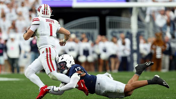 Sep 26, 2026; University Park, Pennsylvania, USA;  Penn State Nittany Lions linebacker Tony Rojas (13) attempts to tackle Wisconsin Badgers quarterback Colton Joseph (1) during the second quarter of the game at West Shore Home Field at Beaver Stadium.  Mandatory Credit: Matthew O'Haren-Imagn Images